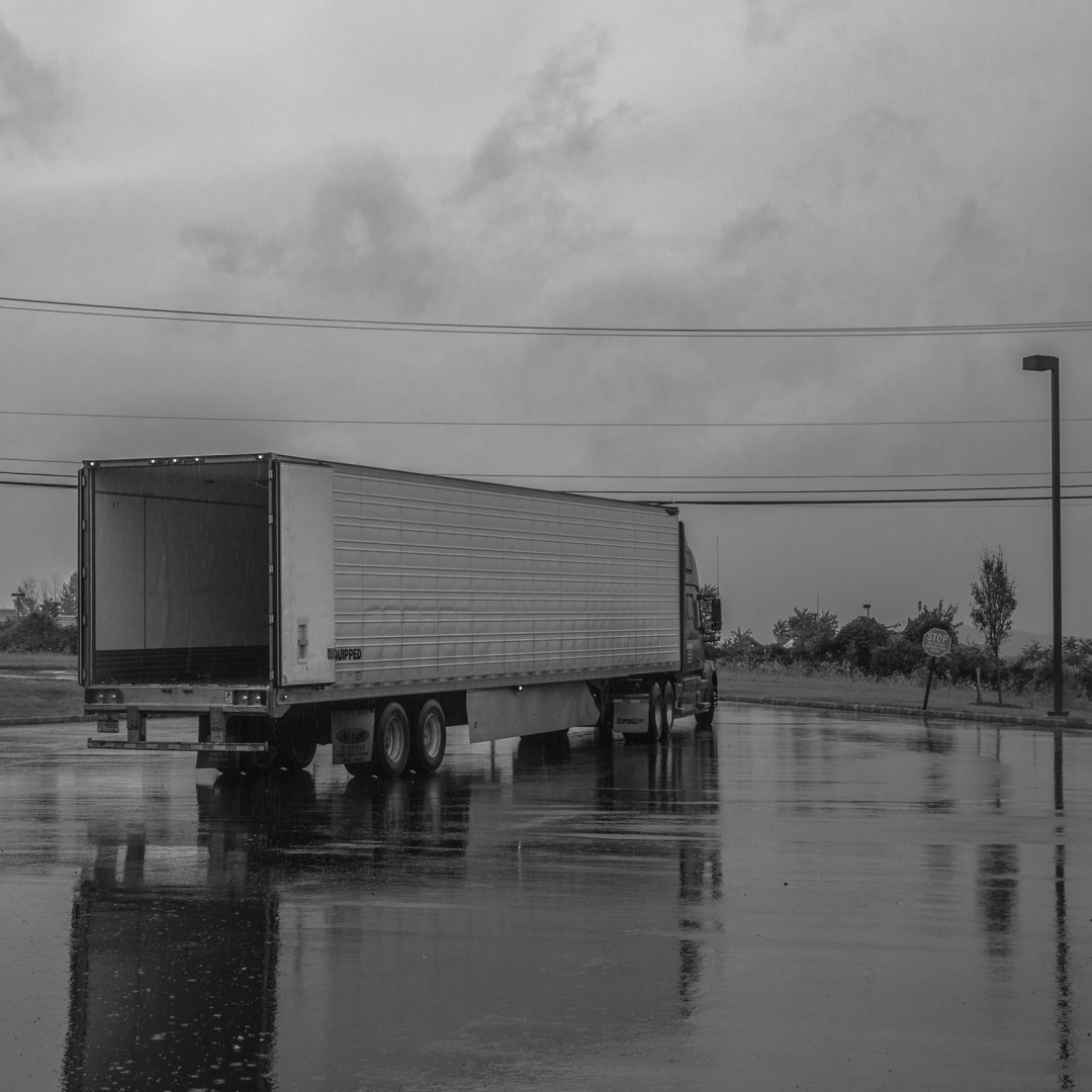 The back of an unloaded truck in the rain